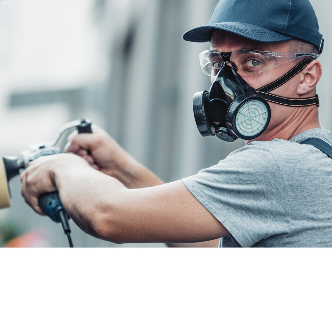 Mann mit Atemschutzmaske, Schutzbrille und blauer  Cap